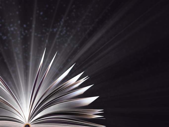Part of an open magic book, bewitched book glows in the darkness, magic light. Education. Dreamy image of a fairytale